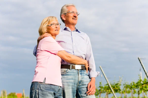 Senior man en vrouw lopen hand in hand — Stockfoto