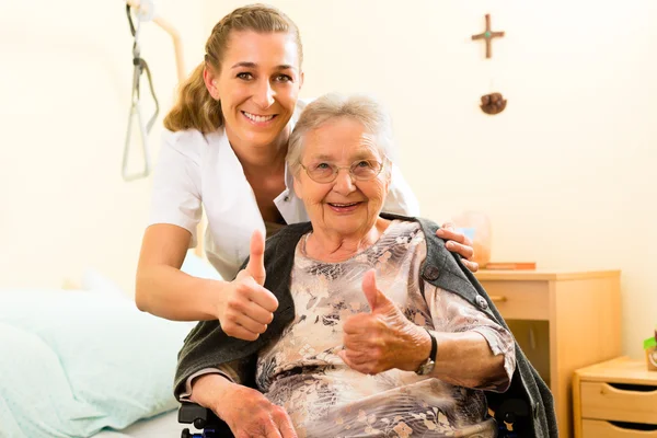 Enfermera y mujer mayor en un asilo de ancianos — Foto de Stock