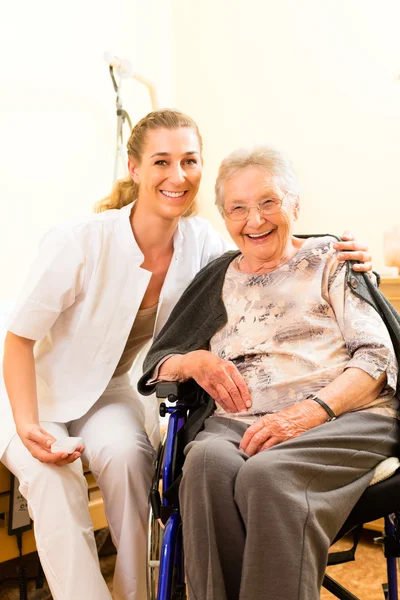 Nurse and female senior in nursing home — Stock Photo, Image