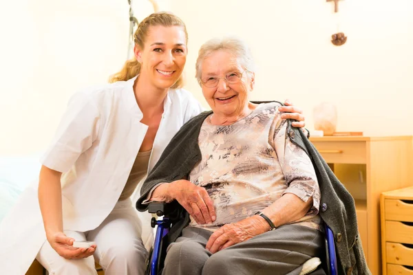 Sjuksköterska och kvinnliga senior i vårdhem — Stockfoto