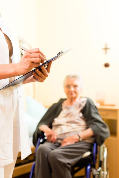 Sjuksköterska och kvinnliga senior i vårdhem — Stockfoto