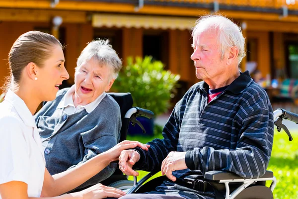 Seniors eating candy in garden of nursing home — Stock Photo, Image