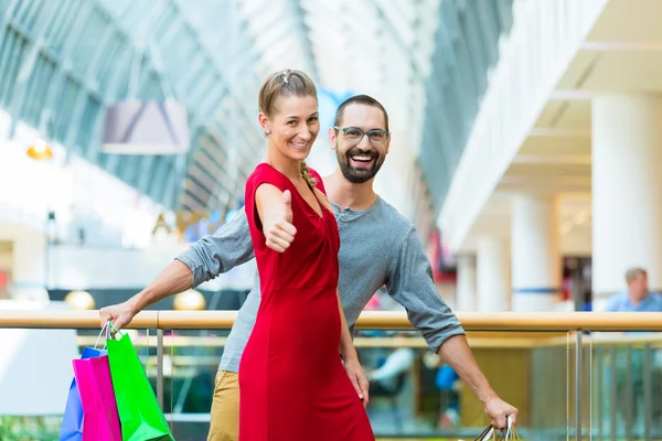 Άνδρα και γυναίκας σε εμπορικό κέντρο με τσάντες — Φωτογραφία Αρχείου