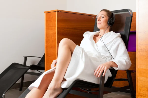 Junge Frau entspannt sich im Wellnessbereich mit Musik — Stockfoto