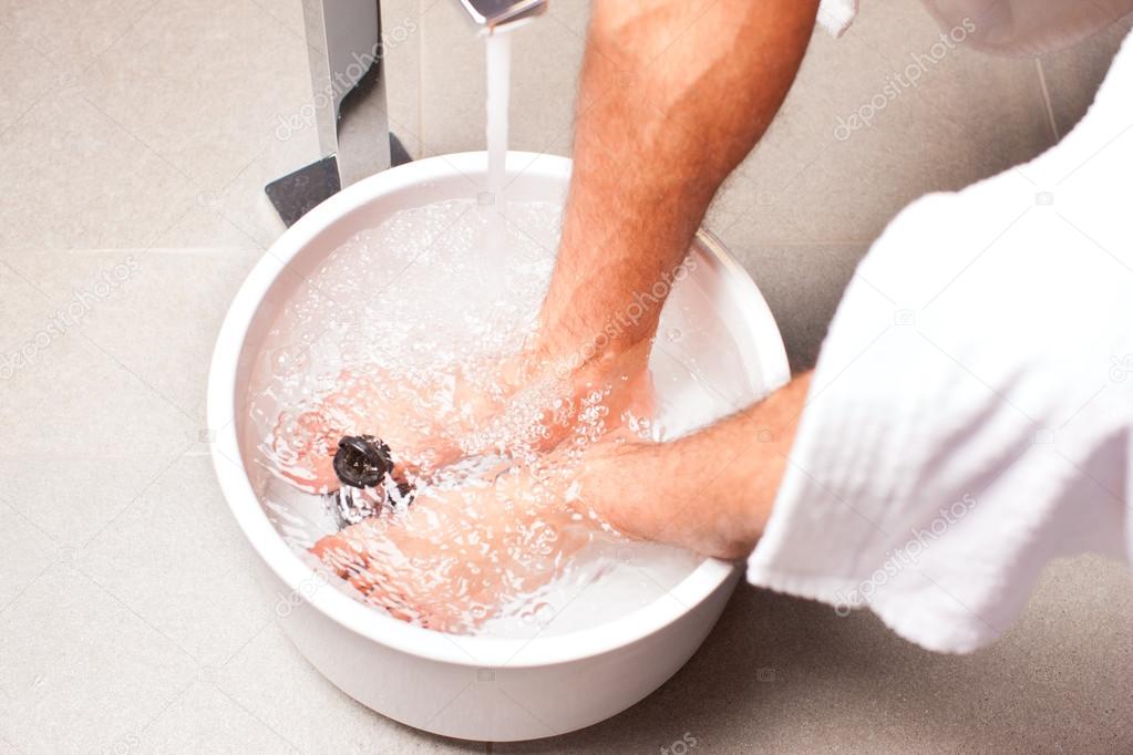 man having hydrotherapy water footbath