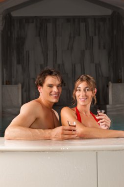Couple drinking tea in swimming pool clipart