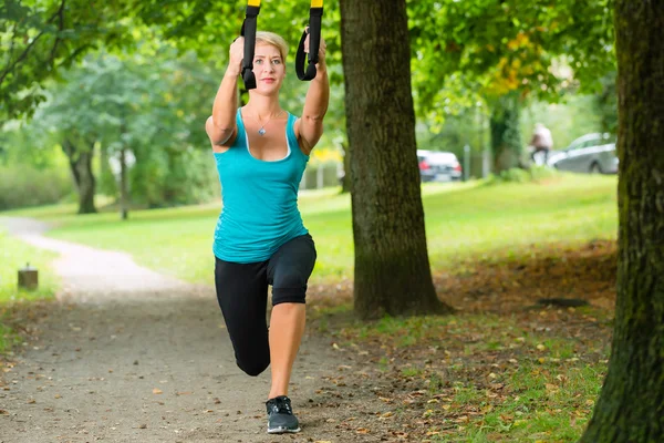 Mujer haciendo suspensión honda entrenador deporte —  Fotos de Stock