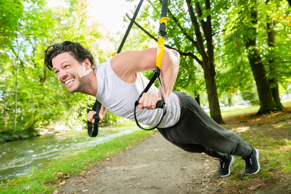 Homem fazendo suspensão treinador sling sport — Fotografia de Stock