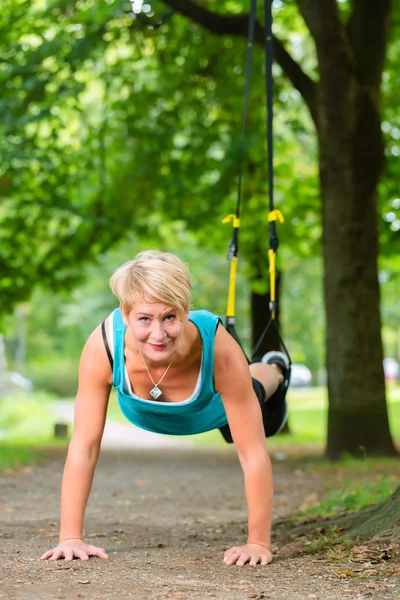 Kvinnan gör fjädring sling tränare sport — Stockfoto