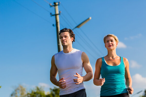 Sport couple running and jogging on rural street
