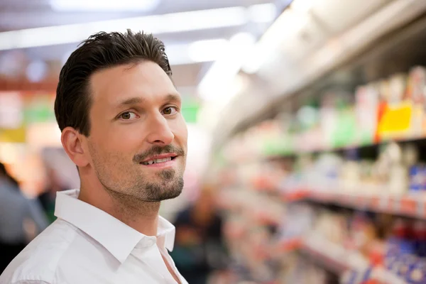 Lachende jonge klant in supermarkt — Stockfoto