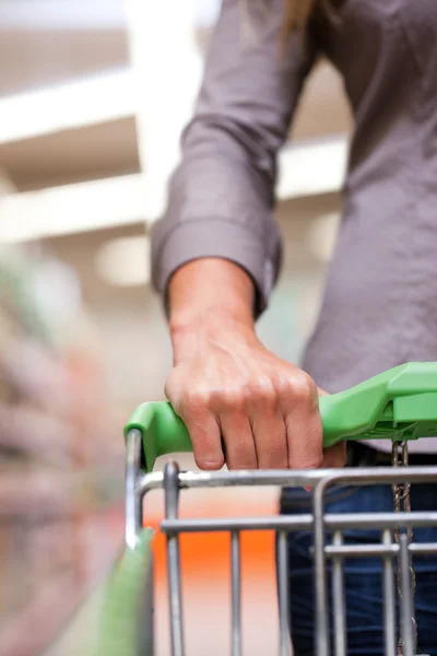 Giovane donna con carrello a spinta nel supermercato — Foto Stock