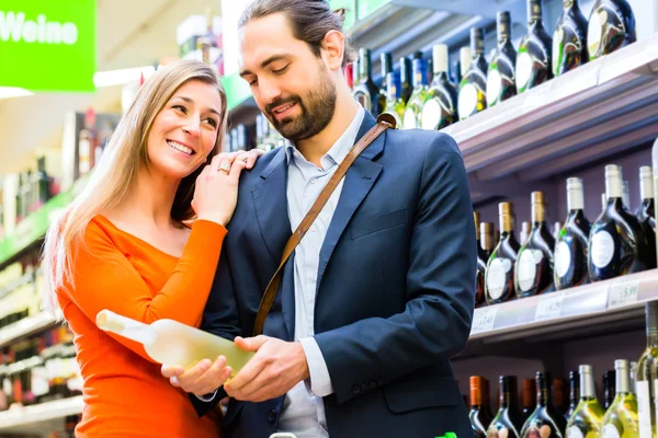 Paar wählt Wein im Supermarkt aus — Stockfoto