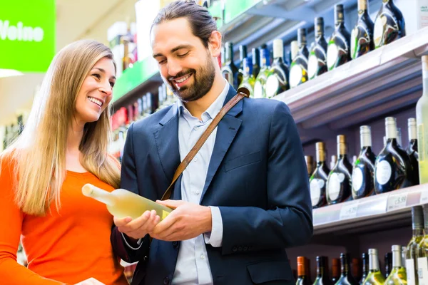 Paar wählt Wein im Supermarkt aus — Stockfoto