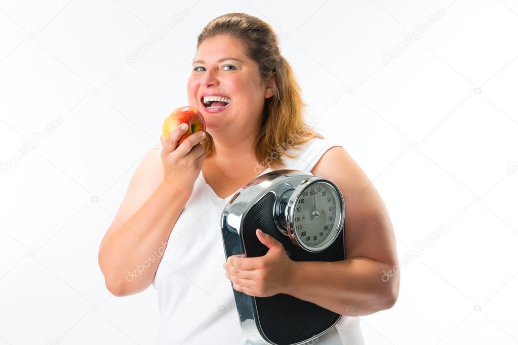 Obese woman with scale under arm and apple