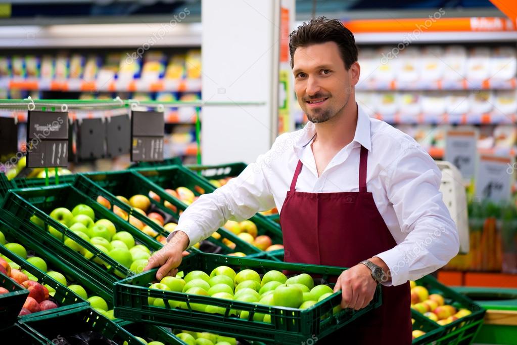 Man in supermarket as shop assistant — Stock Photo © Kzenon 83011844