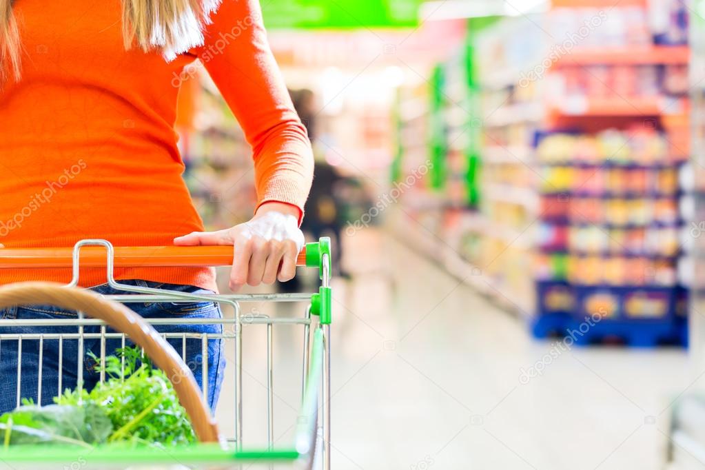 Woman with shopping cart in supermarket