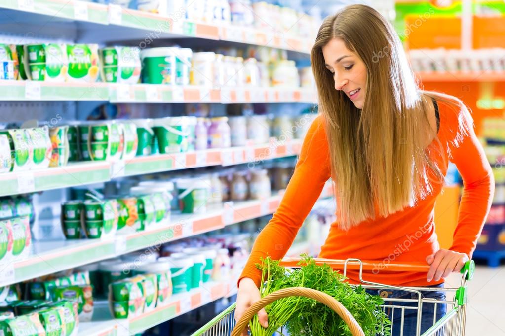 Young woman with pushcart in supermarket