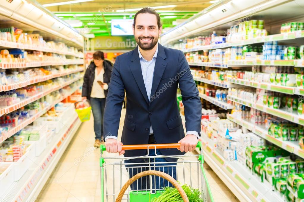 Man with shopping cart in hypermarket