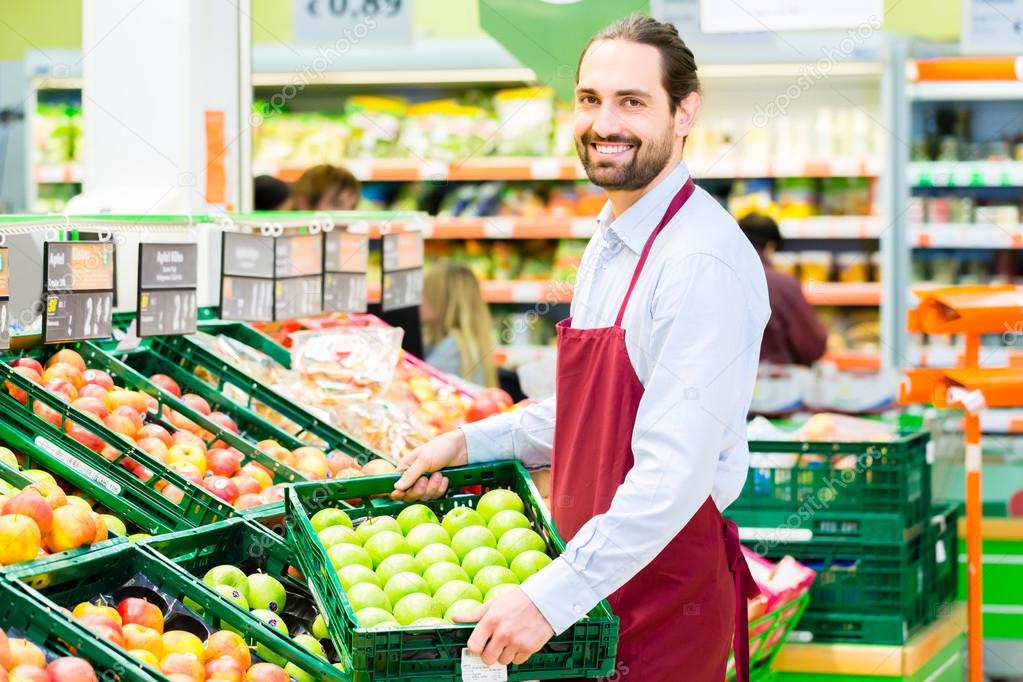 Hypermarket clerk filling up storage racks