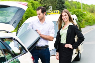 Young businesswoman in front of taxi with luggage clipart