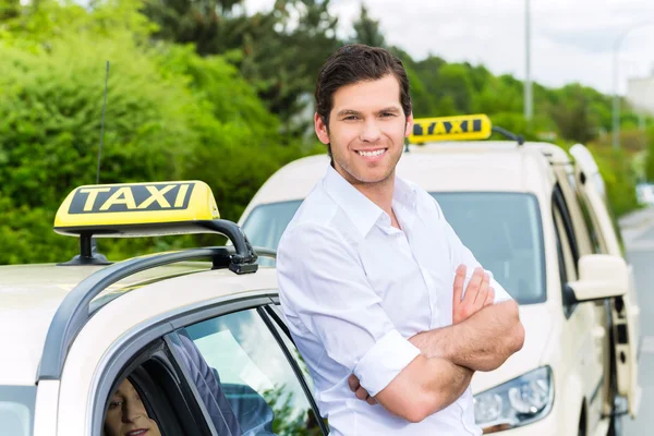 Driver in front of taxi waiting for clients — Stock Photo, Image