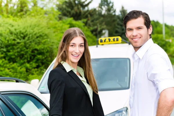 Driver in passenger in front of taxi — Stock Photo, Image