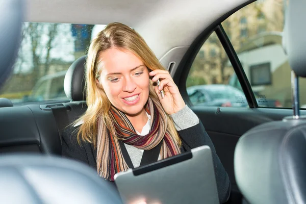 Mujer conduciendo en taxi, ella está en el teléfono — Foto de Stock