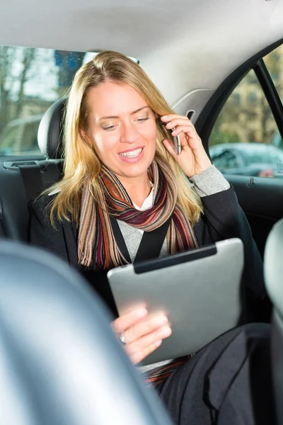 Woman going by taxi, she is on the phone — Stock Photo, Image