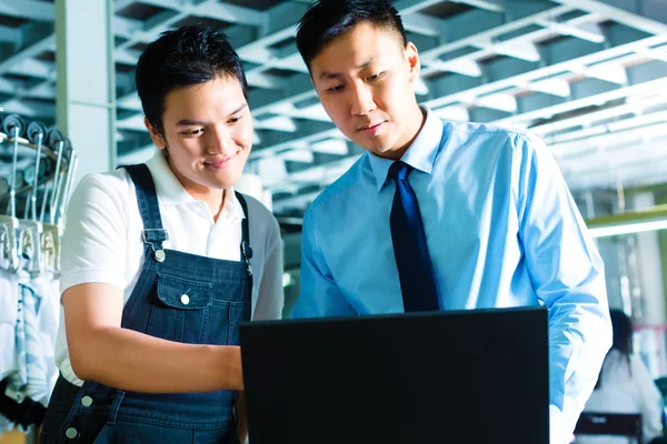 Worker and supervisor with laptop in a factory — Stock Photo, Image