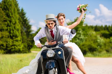Gelin çift motorlu scooter elbisesi ve takım elbise giyen sürüş