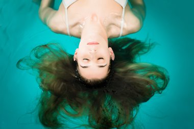 Wellness - Spa veya yüzme havuzunda yüzen genç kadın 