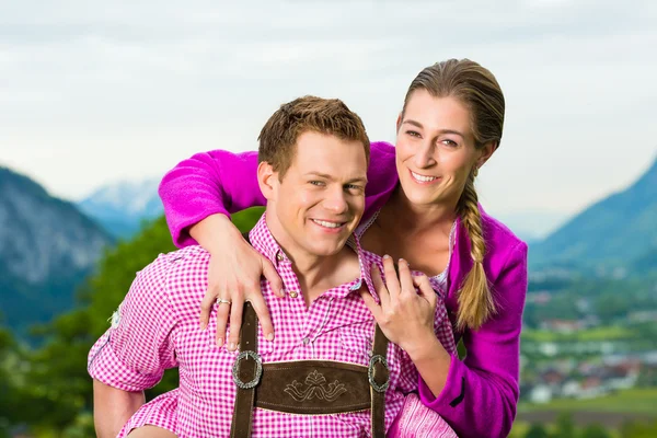 Heureux couple dans la prairie alpine en Tracht — Photo