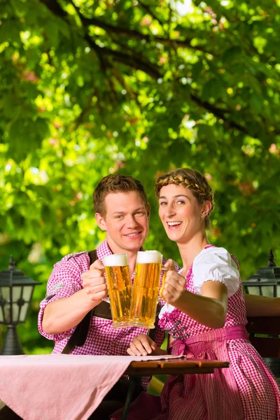 Pareja feliz en el jardín de la cerveza beber cerveza — Foto de Stock