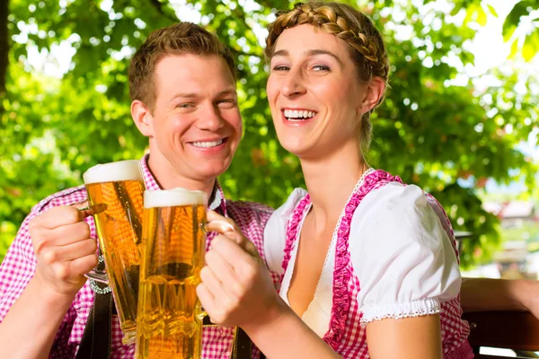 Casal feliz no jardim da cerveja beber cerveja — Fotografia de Stock