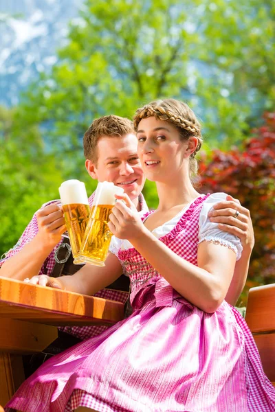 Lyckliga par i ölträdgården dricka öl — Stockfoto