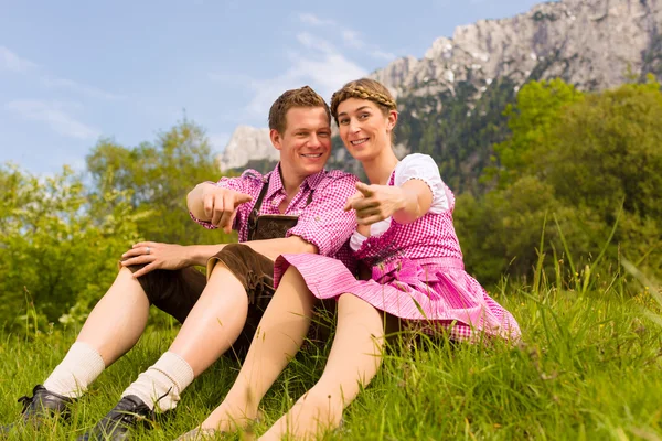 Pareja feliz sentada en el prado alpino —  Fotos de Stock