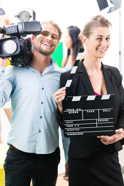 Production team with camera and take clap on film set or studio — Zdjęcie stockowe