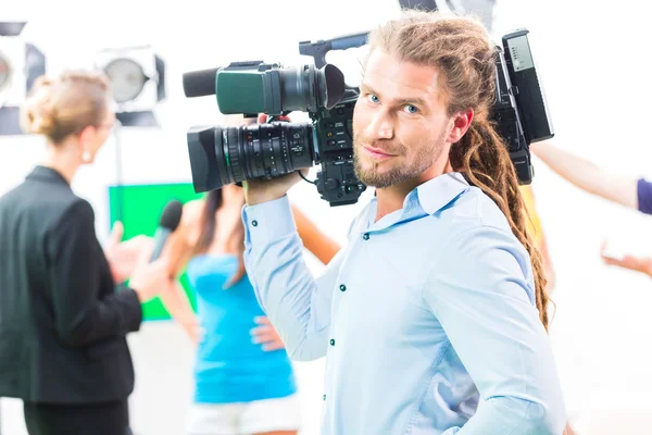 Cameraman shooting with camera on film set — Stockfoto