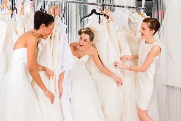 Las mujeres se divierten durante el ajuste de vestido de novia en la tienda —  Fotos de Stock