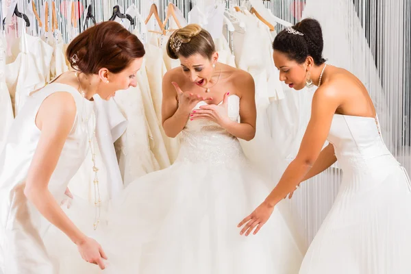 Mulheres se divertindo durante o vestido de noiva montagem na loja — Fotografia de Stock