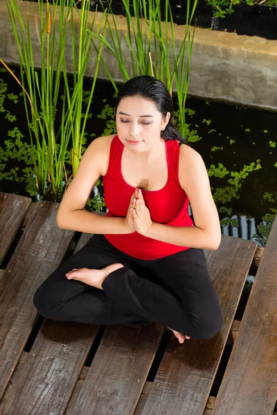 Mulher asiática fazendo ioga em ambiente tropical — Fotografia de Stock