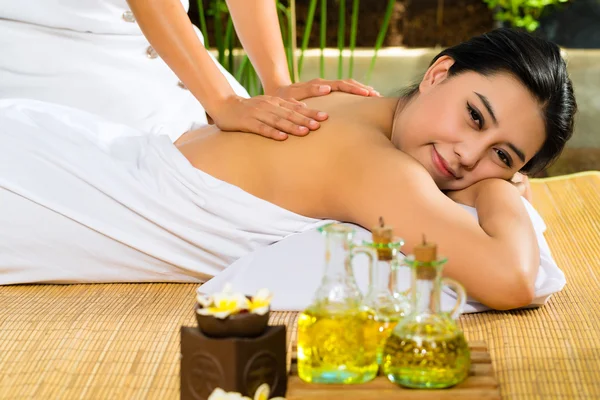 Asian woman having a massage in tropical setting — Stock Photo, Image