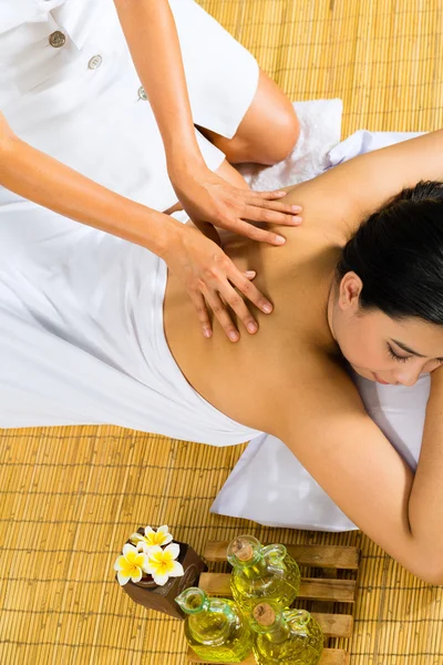 Asian woman having a massage in tropical setting — Stock Photo, Image