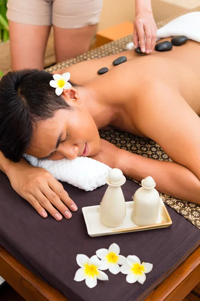 Indonesian man at hot stone wellness massage — Stock Photo, Image