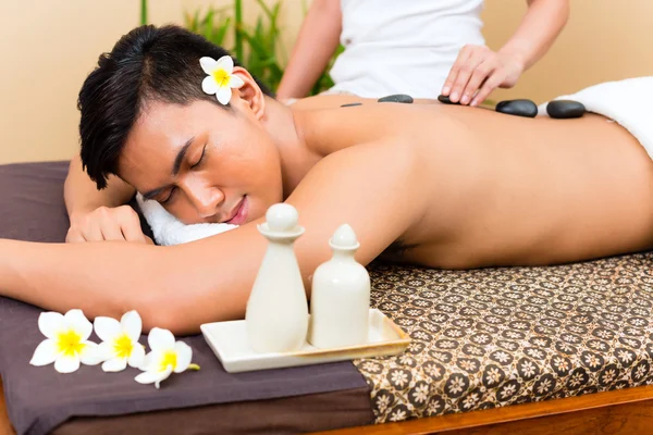 Indonesian man at hot stone wellness massage — Stock Photo, Image