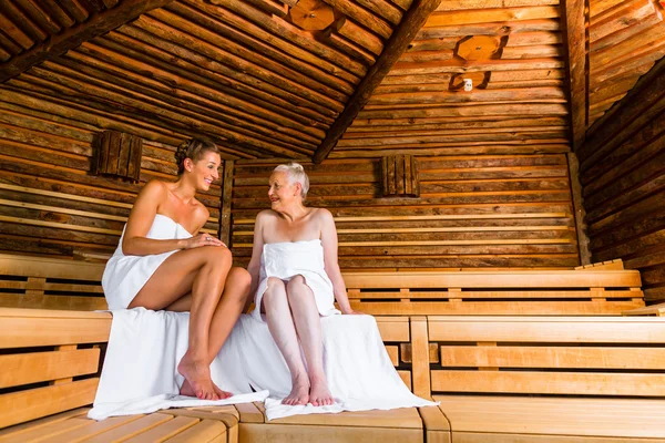 Senior e jovem mulher na sauna suando no calor — Fotografia de Stock