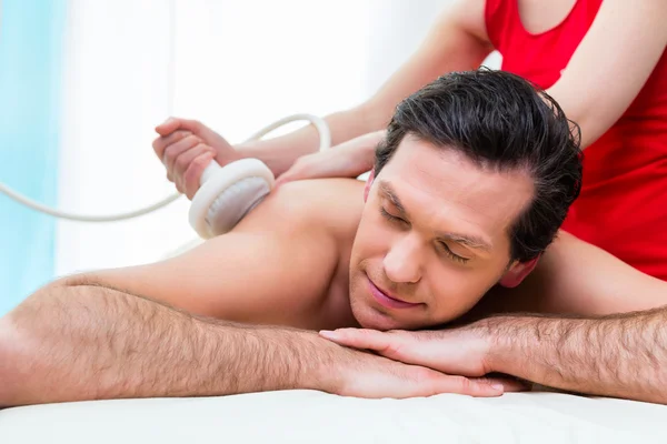 Людина має масаж спини в оздоровчому спа-центрі — стокове фото