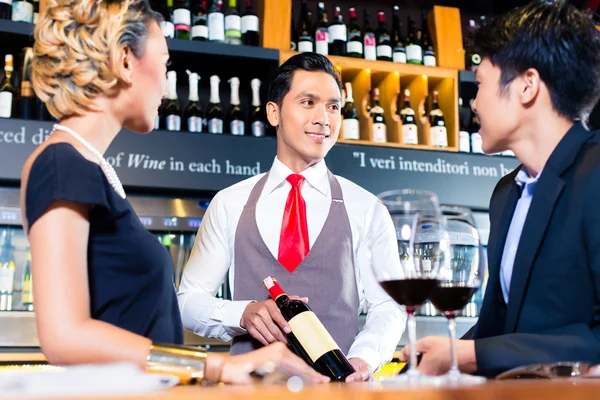 Aziatische paar proeverij rode wijn in bar — Stockfoto