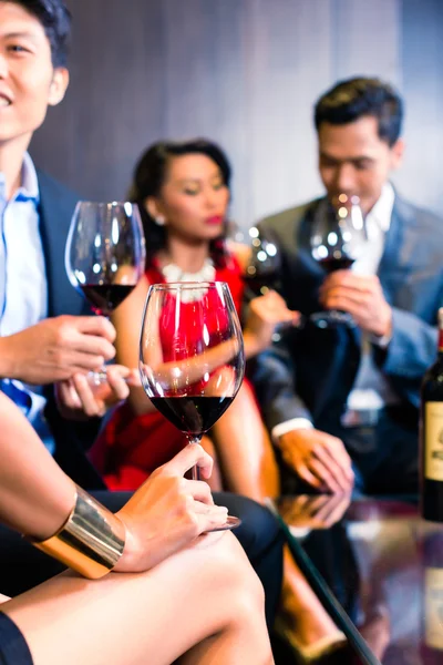 Asiatiska vänner dricka vin i bar — Stockfoto